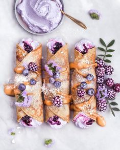 crepes with blueberries, raspberries and other toppings on them