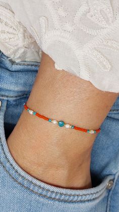 "Dainty seed beads bracelet with turquoise and freshwater pearls. Set against a coral red background the turquoise coin and tiny beads add a sparkling and contrasting accent. Closes with a stainless steel clasp and comes with an extender chain. On-trend, feminine and perfect as an addition to your bracelet stack! H O W * T O * O R D E R The bracelet is available in gold, rose gold and silver (rose gold and silver not featured). Please select a finish in the drop down box. K E Y * F E A T U R E S Silver Beads Bracelet, Red Beads Bracelet, Orange Beaded Bracelets, Turquoise Coral Jewelry, Tiny Bead Bracelet, Seed Beads Bracelet, Red Beaded Bracelet, Orange Bracelet, Red Bracelet