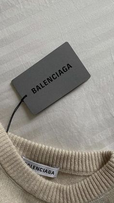 a label on a sweater that says balenocaga next to a white t - shirt