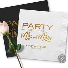 a white rose sitting on top of a piece of paper next to a napkin with the words party with the new mr and mrs