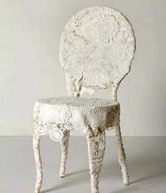 an old white chair sitting on top of a table