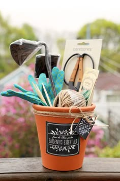 an orange pot with gardening tools in it