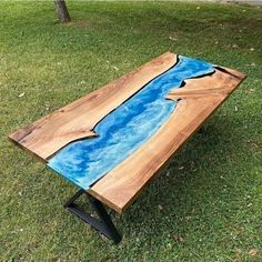 a table made out of wood with blue paint on the top and black metal legs