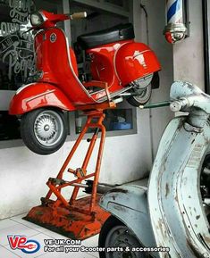 a red scooter parked next to a white moped