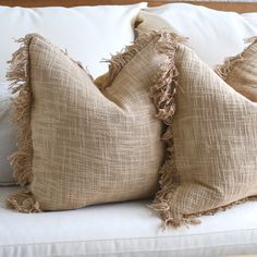 two burlap pillows on a white couch