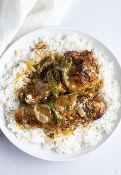 a white plate topped with rice and meat