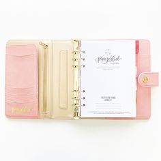 a pink and gold planner book on a white background