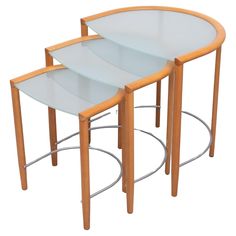 three nesting tables with glass tops on metal bases