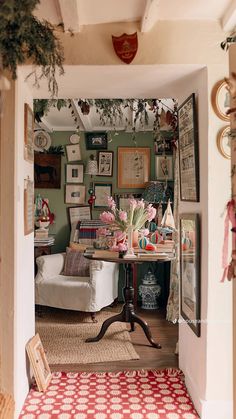 an open doorway leading to a living room filled with furniture and pictures on the wall