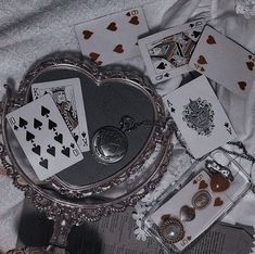 playing cards are laying on the bed next to an antique mirror and keychain