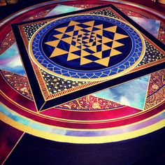 an artistically designed table top with gold, blue and red designs on the surface