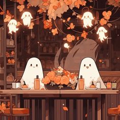 two white ghost sitting at a table with orange flowers in front of them and lights hanging from the ceiling