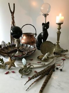 a table topped with lots of different types of metal items and candle holders on top of it