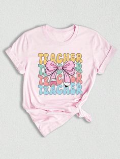 a pink t - shirt with the words teacher on it and a bow at the front