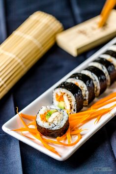 sushi on a white plate with chopsticks next to it