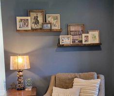 a living room filled with furniture and framed pictures on the wall above it's coffee table