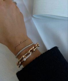 a woman's arm with two bracelets on it