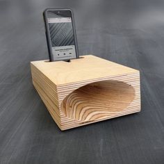 a cell phone sitting on top of a wooden block with a hole in the middle