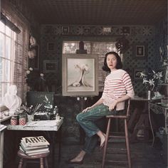 a woman sitting on top of a wooden chair