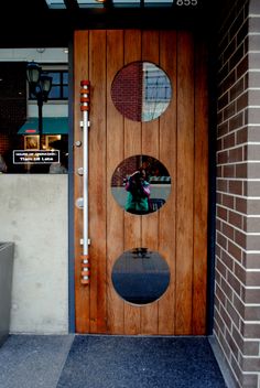 a wooden door with three circular mirrors on it