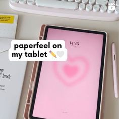 a tablet sitting on top of a desk next to a keyboard and paper with the words paperfeel on my tablet