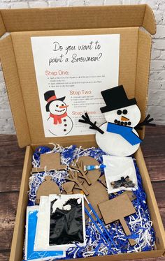 an open cardboard box filled with snowmen and other items to make it look like they are