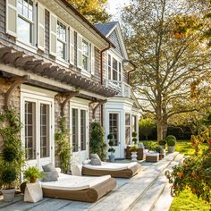 an outdoor patio with chaise lounges and potted plants