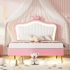 a pink and white bed with a teddy bear sitting on the floor next to it