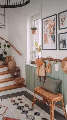 a room with some pictures on the wall and a chair in front of it next to a stair case