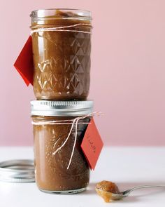 two mason jars filled with peanut butter on top of a table