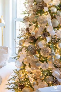 a white christmas tree with gold and silver ornaments