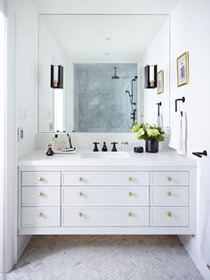 a white bathroom with two sinks, mirrors and pictures on the wall above it that says back to top