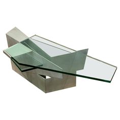 a glass and metal table with an upside down design on it's side, against a white background