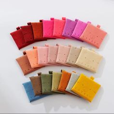 several different colors of felts laid out on top of each other, including pink, yellow, green, and blue