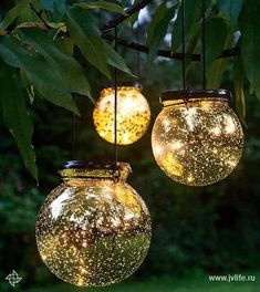 three glass jars with lights hanging from them