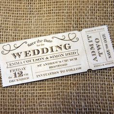 a wedding ticket sitting on top of a burlock covered tablecloth with the words save the date for the wedding