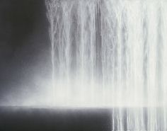 a black and white photo of water spouting from the side of a building