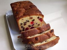 a loaf of fruit bread sitting on top of a white plate