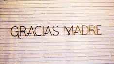 graffiti on the side of a building that says, gracias madre in black ink