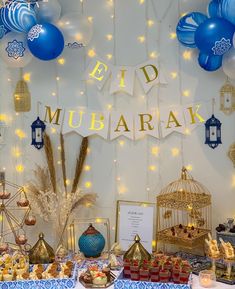 a table topped with lots of food next to a sign that says eid mubarak