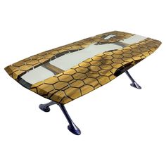 an ironing board is sitting on top of a metal stand and has a yellow snake skin pattern