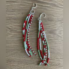 red, white and green seed beaded earrings on wood table with silver earwires