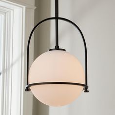 a light fixture hanging from the side of a wall in a room with white walls