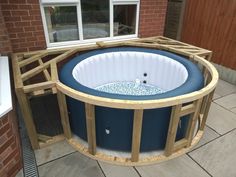 an inflatable hot tub sitting on top of a patio next to a brick building