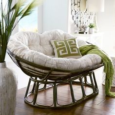 a living room filled with furniture and a large vase on top of a hard wood floor