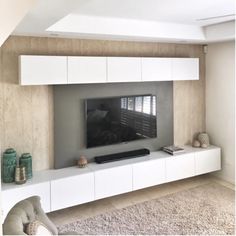 a flat screen tv sitting on top of a white entertainment center in a living room