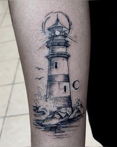 a black and white lighthouse tattoo on the leg