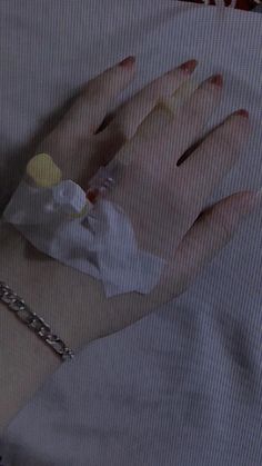 a woman's hand wrapped in bandages on top of a white sheeted bed