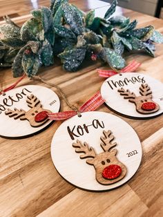 three wooden ornaments with reindeer faces on them