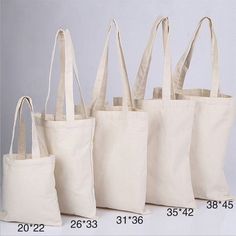 four canvas bags are shown with measurements for the size and width tote bag sizes